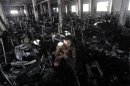 A man inspects the burnt interior of a garment factory after a fire in Dhaka