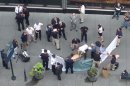 In this photo made with a cell phone, officials examine the body of gunman Jeffrey Johnson, who was killed by police gunfire after he fatally shot Steven Ercolino, an executive at his former company, outside the Empire State Building, Friday, Aug. 24, 2012, in New York. At least nine bystanders were hit by gunfire in the confrontation. (AP Photo/Lee Weinstein)