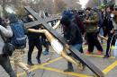 Masked demonstrators carry a cross with Jesus Christ during a protest against government education reforms in Santiago