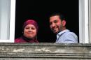 Tunisian Abdul bin Muhammad Abbas Ouerghi (R), a former Guantanamo inmate who was resettled in Uruguay, and his bride Samira smile from a window of a house in Montevideo on June 5, 2015