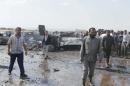 Men inspect the damage at a fuel market hit by a car bomb in the Maarat Al-Naasan area of Idlib