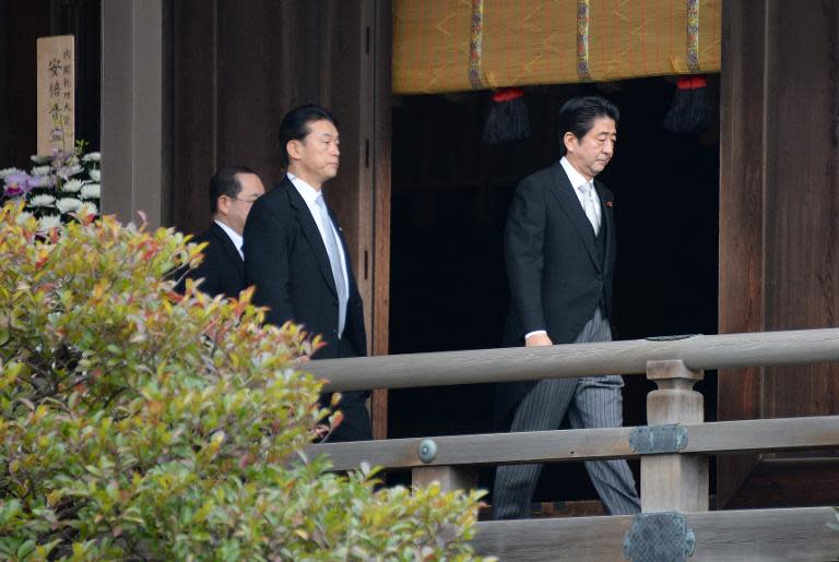 Japanese Prime Minister Shinzo Abe (R) walks away after paying homage at the altar of the controversial Yasukuni war shrine in Tokyo on December 26, 2013
