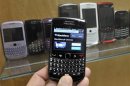 A BlackBerry device is shown in front of products displayed in a glass cabinet at the Research in Motion offices in Waterloo
