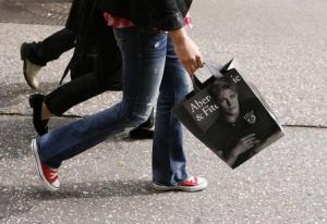 A shopper walks down Fifth Avenue with an Abercrombie …