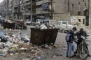 Unos sirios dialogan el domingo en una calle llena de basura en el barrio de Tarik Al Bab, en Alepo