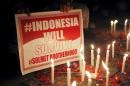 A man holds a placard during a peace gathering at the site of this week's militant attack in central Jakarta, Indonesia