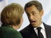 French President Nicolas Sarkozy, right, reacts to German Chancellor Angela Merkel after a meeting on the financial crisis in Berlin, Germany, Sunday, Oct. 9, 2011. The two leaders of the eurozone's two biggest economies, say they have reached agreement on strengthening Europe's shaky banking sector. (AP Photo/Martin Meissner)