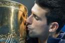 Novak Djokovic of Serbia kisses his trophy after beating Tomas Berdych of the Czech Republic in the China Open men's singles final on October 5, 2014, in Beijing
