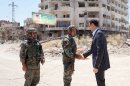 This image posted on the official Facebook page of the Syrian Presidency on Thursday, Aug. 1, 2013 purports to show Syrian President Bashar Assad shaking hands with a solider during Syrian Arab Army day in Darya, Syria. Syrian state-run TV says Assad has visited a tense Damascus suburb to inspect his troops on the occasion of the country's Army Day. The visit on Thursday is Assad's first known public trip outside the capital, his seat of power, since he visited the Baba Amr district in the central city of Homs after troops seized it from rebels in March 2012. Daraya, just south of Damascus, was held by rebels for a long time and it took the army weeks of heavy fighting to regain control earlier this year. (AP Photo/Syrian Presidency via Facebook)