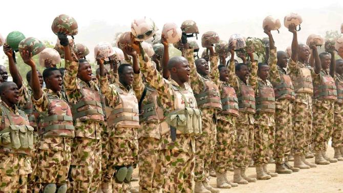 Picture released by State House Photo on February 26, 2015 shows soldiers fighting Boko Haram Islamists cheering Nigerian President Goodluck Jonathan on his arrival in Mubi, recently recaptured from insurgents