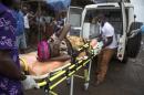 A pregnant woman suspected of contracting Ebola is lifted by stretcher into an ambulance in Freetown