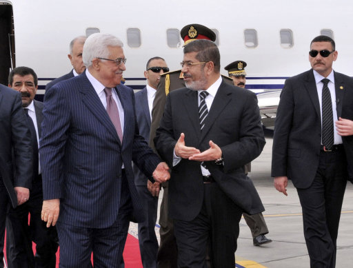In this photo released by the Egyptian Presidency, Palestinian President Mahmoud Abbas, second left, walks with Egyptian President Mohammed Morsi, center, following Abbas' arrival in Cairo, Egypt, for the Organization of Islamic Cooperation summit, Tuesday, Feb. 5, 2013. (AP Photo/Egyptian Presidency)