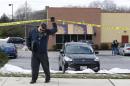 An investigator walks beneath a police tape line at the scene of a shooting at a shopping center in Abingdon, Md., Wednesday, Feb. 10, 2016. A man opened fire inside a shopping center restaurant during lunchtime. (AP Photo/Patrick Semansky)