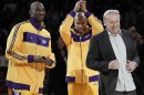 En esta fotografía de archivo del 26 de octubre de 2010, se ve al dueño de los Lakers de Los Angeles Jerry Buss, derecha, junto a Kobe Bryant, izquierda, y Derek Fisher, durante la entrega del anillo de campeones de la NBA previo a un partido ante los Rockets de Houston en Los Angeles. (Foto AP/Chris Carlson, File)