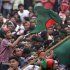 A boy waves a Bangladesh national flag as he chants a slogan before a mass funeral as the body of Rajib Haider arrives at Shahbagh intersection in Dhaka