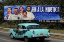 Car drives past a poster of the five Cuban prisoners in U.S. jails, in Havana