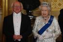 Britain's Queen Elizabeth II, right, poses with President of Ireland Michael D. Higgins, before a state banquet given in honour of the Irish President, at Windsor Castle Tuesday April 8, 2014, in Windsor, England. Guests and dignitaries including Irish Prime Minister, Enda Kenny and Northern Ireland's Deputy First Minister Martin McGuinness attending the banquet at the end of the first day of a state visit by Ireland's Michael D. Higgins. Ireland's Michael D. Higgins is making the first state visit by a president of the republic since it gained independence from Britain. Camilla Duchess of Cornwall at left. (AP Photo / Dan Kitwood)