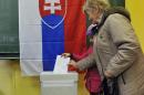 A woman with a family member casts her vote on March 15, 2014 in Bratislava during the first round of presidential elections