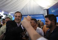 <p>               Greek conservative leader Antonis Samaras of New Democracy visits an elections kiosk in Syntagma square in central Athens, Monday, June 11, 2012. Greeks go to the polls again on Sunday, June 17. (AP Photo/Petros Karadjias)