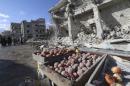 Produce are covered in dust as people inspect a site hit by what activists said were airstrikes carried out by the Russian air force on a busy market place in the town of Ariha, in Idlib province, Syria
