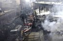 Afghan policemen and fire fighters investigate the scene of a burning market in Kabul, Afghanistan, Sunday, Dec. 23, 2012. Hundreds of shops at a market were burnt in a fire, but no causalities were reported. (AP Photo/Musadeq Sadeq)