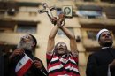 A protester holds a cross and Koran during a protest demanding that President Mohamed Mursi resign at Tahrir Square in Cairo