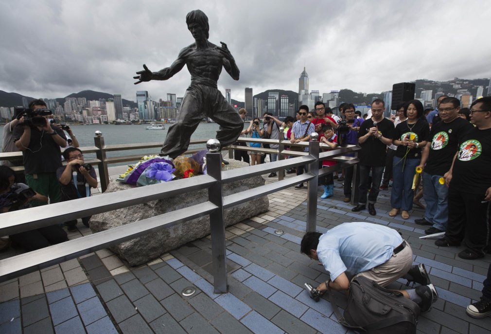 A fan pays his respects in front of a bronze statue of kung fu legend Bruce Lee in Hong Kong