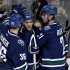 Vancouver Canucks Schroeder is congratulated by teammates Hansen and Raymond after scoring his second goal of night during NHL hockey in Vancouver