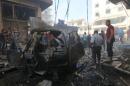 Residents inspect a damaged site after airstrikes on a market in the rebel controlled city of Idlib