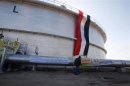 An employee of the state-run South Oil Company (SOC) walks near a new oil storage tank near the southern city of Basra