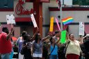 Gay rights groups and others protest and hold a "kiss-in" outside the Decatur, Ga., Chick-fil-A restaurant Friday, Aug. 3, 2012 as a public response to a company official who was quoted as supporting the traditional family unit. About two dozen protesters gathered on the busy corner to voice their views. (AP Photo/David Tulis)