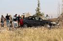 Police forensic experts examine a car after a blast detonated by two militants, in the countryside of Haymana near Ankara