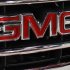 This Oct. 28, 2011 photo, shows the GMC nameplate on the grille of a 2012 GMC Sierra at the 41st annual South Florida International Auto Show, in Miami Beach, Fla. General Motors said Wednesday, Nov. 9, 2011, it earned $1.7 billion in the third quarter, down 15 percent from a year earlier. (AP Photo/Lynne Sladky)