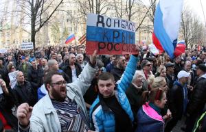 Ativistas pró-russos segurar um cartaz dizendo "Crimeia, ...