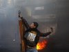 A Palestinian protester uses a slingshot to throw a stone during clashes with Israeli soldiers in Hebron