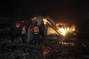 Palestinians try to douse a fire after Israeli air raids hit a Hamas security site in Gaza City