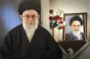 Iran's Supreme Leader Ayatollah Ali Khamenei sits next to a portrait of late leader Ayatollah Ruhollah Khomeini in Tehran