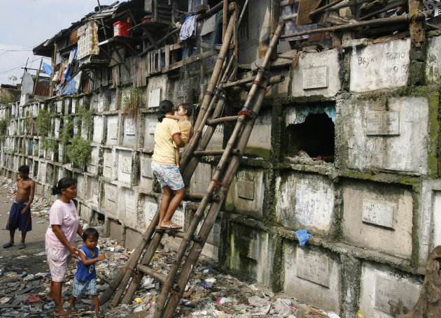 Residents climb into their houses atop gravestones inside a cemetery in Manila