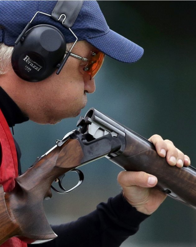 Russia's Valeriy Shomin blows into his rifle during the skeet men's qualification round at the Royal Artillery Barracks during the London 2012 Olympic Games