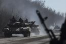 Ukrainian troops ride on tanks near Artemivsk, eastern Ukraine, Tuesday, Feb. 24, 2015. Ukrainian officials said they haven't yet started pulling heavy weapons back from a frontline in eastern Ukraine because of continued rebel violations of a cease-fire deal. (AP Photo/Evgeniy Maloletka)