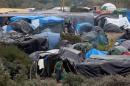 File photo of migrants near tents in the "New Jungle" make-shift camp as unseasonably cool temperatures arrive in Calais
