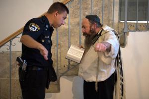 An Israeli police man askes a Jewish man reciting the&nbsp;&hellip;