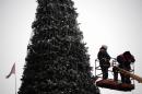 Workers decorate a Christmas tree at the main square in the eastern Ukrainian city of Donetsk on December 15, 2014