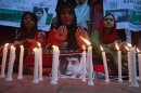 NCHD supporters pray next to pictures of schoolgirl Yousufzai, who was shot by the Taliban, during a candlelight vigil in Karachi