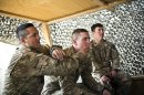 US soldiers share a cigarette at Command Outpost AJK in Maiwand District, Kandahar Province, Afghanistan