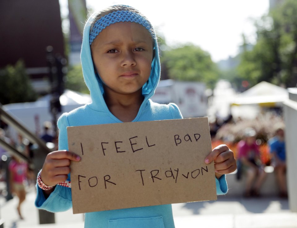 Tatum Stoball, 5, of Madison, Wis., holds up a sign during a protest of the acquittal of George Zimmerman, Sunday, July 14, 2013, in Madison, Wis. Zimmerman was found not guilty in the 2012 shooting death of Trayvon Martin in Florida on Saturday. (AP Photo/Morry Gash)