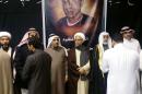 In this picture taken Tuesday, Jan. 5, 2016, by a citizen journalist, which has been verified and is consistent with other AP reporting, Sheikh Hassan al-Saffar, a top Shiite cleric from Qatif, center, stands with family members of Shiite Sheikh Nimr al-Nimr and other Shiite notables, as they receive condolences on the second day of mourning for him at a mosque in the village of al-Awamiya, eastern Saudi Arabia. Al-Nimr was an outspoken critic of Saudi Arabia's Sunni monarchy but denied ever calling for violence. His execution on Saturday has sparked outrage among Shiites across the region. The poster behind the men shows Mohammed Ali Abdulkarim Suwaymil a young Saudi Shiite who was executed at the same time as al-Nimr. (verified UGC via AP)