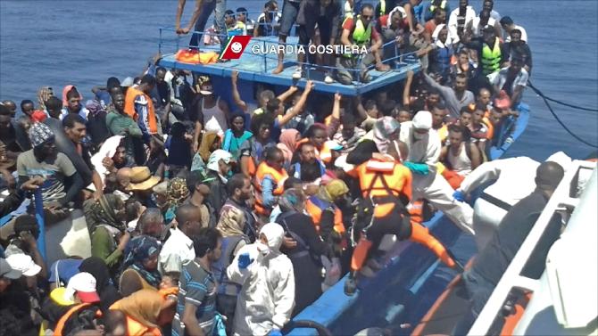 Migrants waiting on an overcrowded boat being helped during a rescue operation off the coast of Libya as part of the Frontex-coordinated Operation Triton