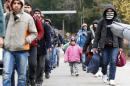 Migrants walk along street after passing Austrian-German border near Wegscheid