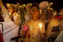 A boy holds a candle and flowers as he attends a protest to condemn the attack by a gunman at the beach of the Imperial Marhabada hotel in Sousse